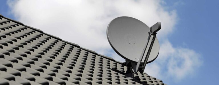 Eine Satellitenschüssel ist auf einem Dach befestigt.